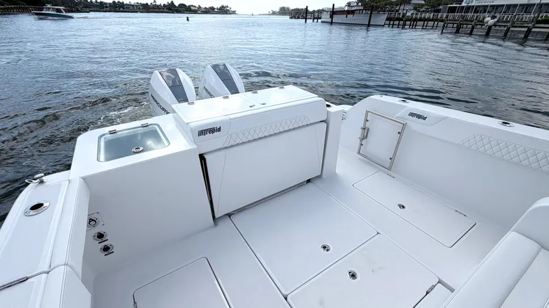 Slide: The Image of Intrepid 35 VALOR 2026: Spacious deck with dual engines, on calm water near a shoreline. - 29