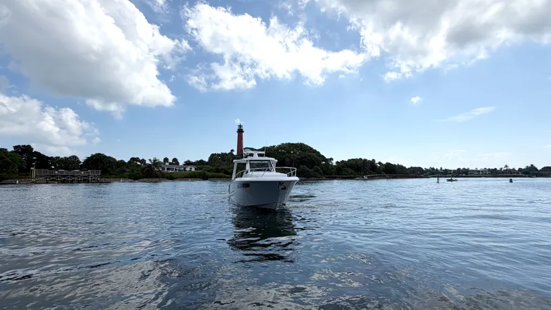 Slide: The Image of An Intrepid 35 VALOR boat from 2026 on calm water with a lighthouse in the background. - 3