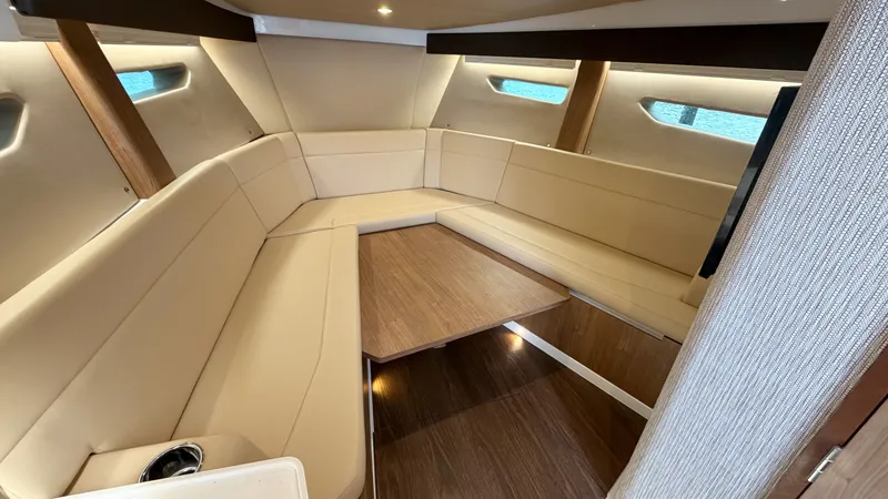 Slide: The Image of Intrepid 35 VALOR 2026: Sleek interior with cream upholstery and wooden table. - 35
