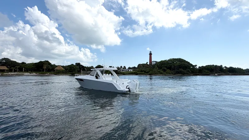 Slide: The Image of Intrepid 35 VALOR 2026 on calm water near a lighthouse and wooded shoreline. - 5