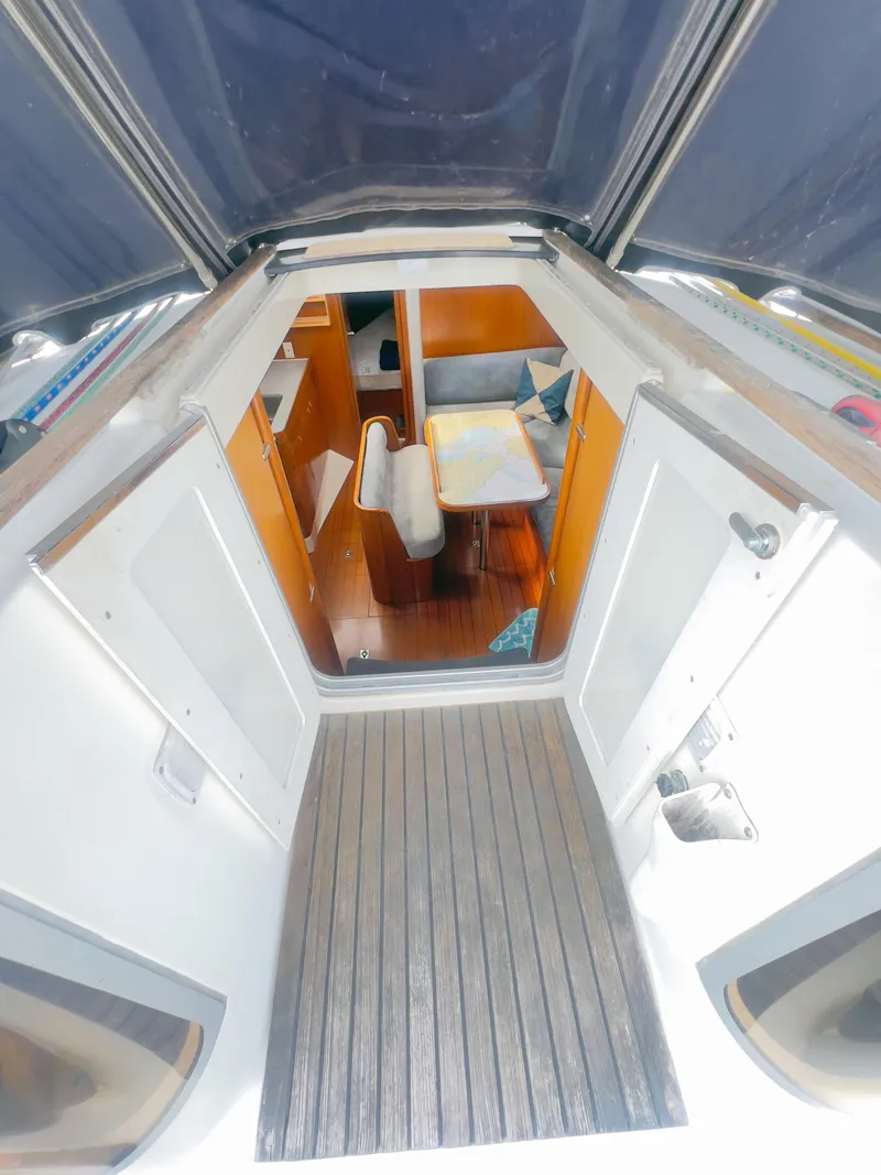 Slide: The Image of Interior view of a 1990 Beneteau 370 sailboat, featuring a cozy cabin and seating area. - 12