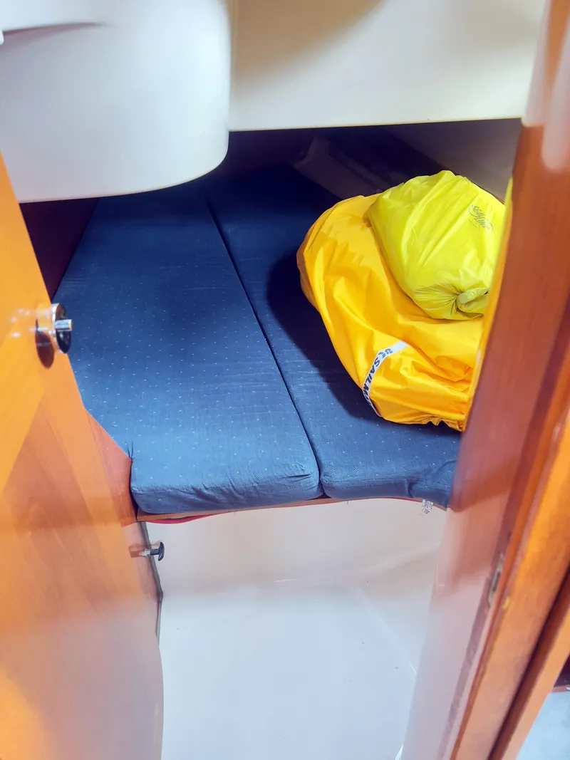Slide: The Image of Cozy cabin interior of 1990 Beneteau 370 sailboat with blue mattress and yellow bag. - 14