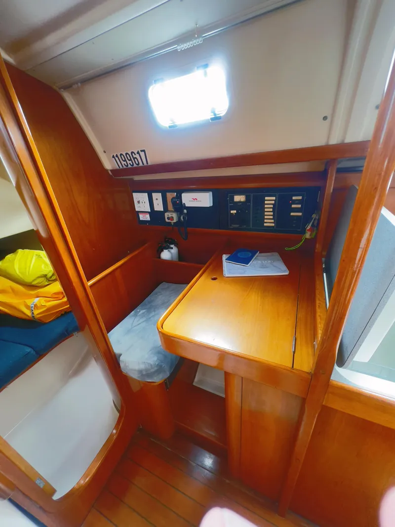 Slide: The Image of Cozy cabin interior of 1990 Beneteau 370 sailboat with navigation station and wooden finish. - 18
