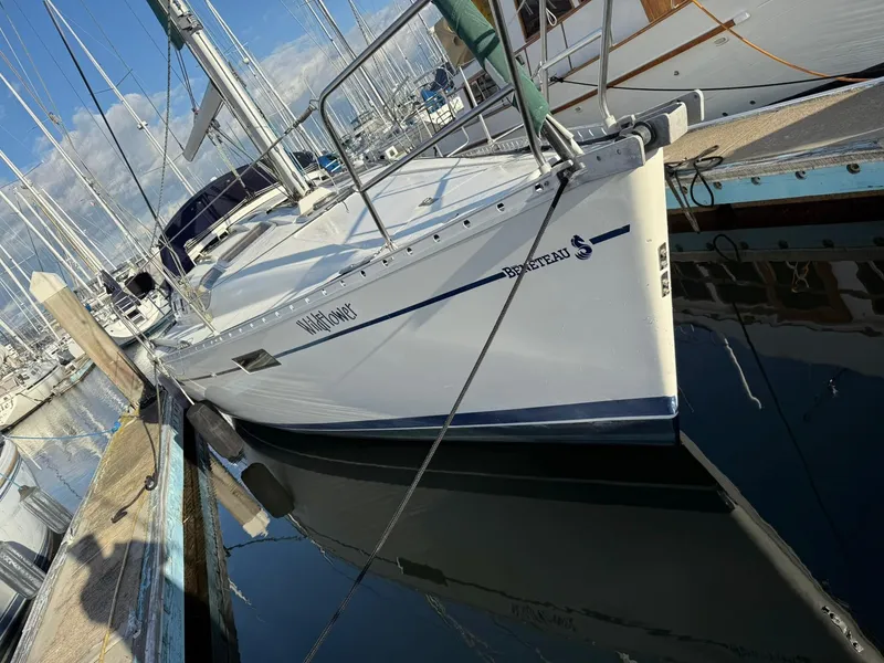 Slide: The Image of 1990 Beneteau 370 sailboat docked in a marina, reflecting on calm water. - 2