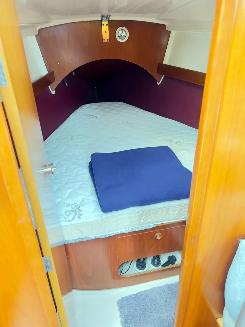 Slide: The Image of Cozy cabin interior of 1990 Beneteau 370 sailboat with bed and wooden finish. - 20
