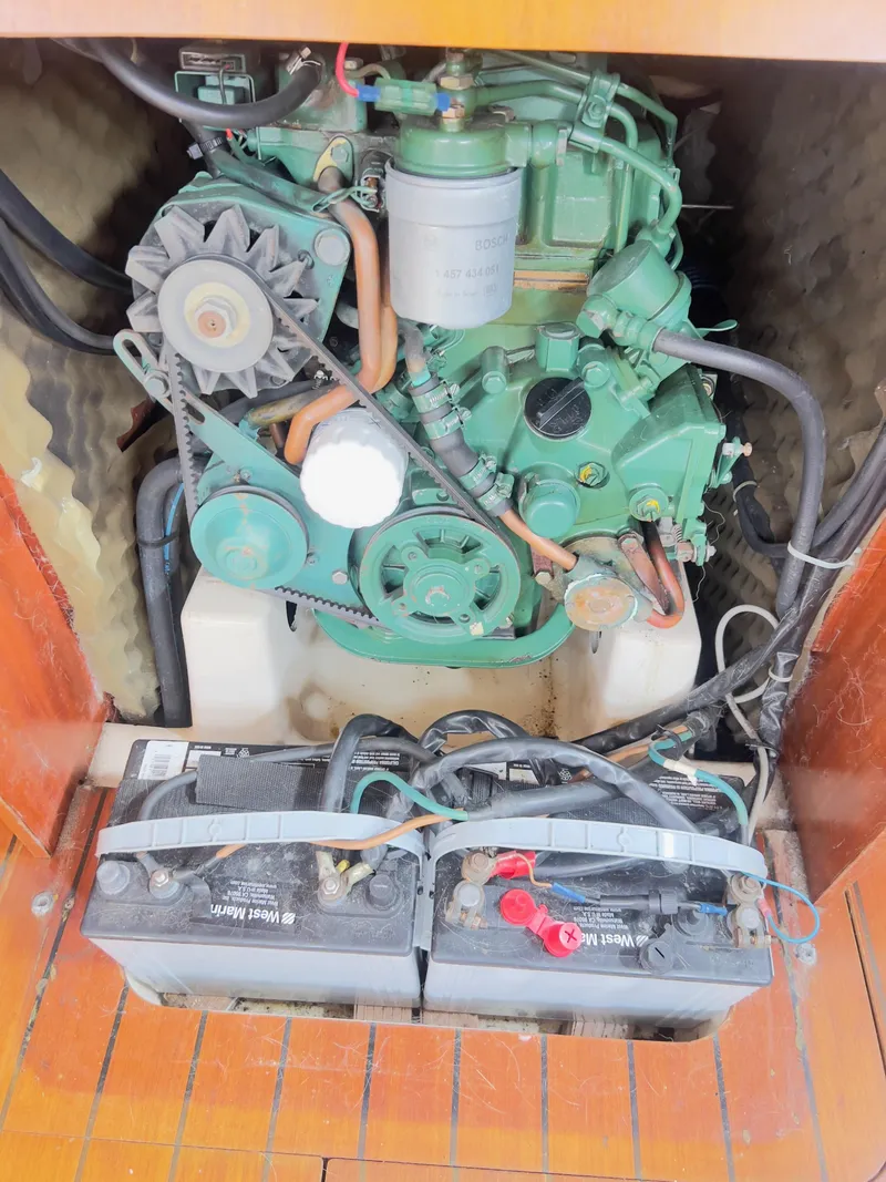 Slide: The Image of Engine compartment of a 1990 Beneteau 370 sailboat with visible batteries and mechanical components. - 21