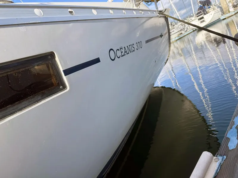 Slide: The Image of 1990 Beneteau Oceanis 370 sailboat docked in marina, reflecting on calm water. - 8