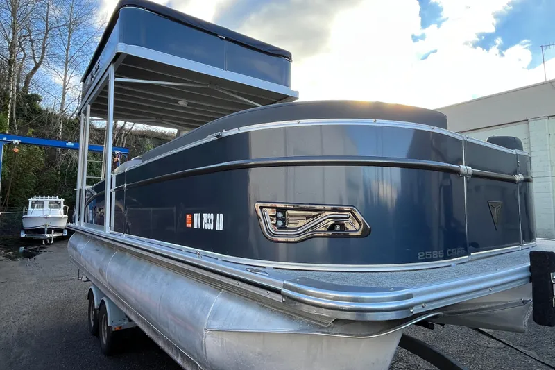 The Image of 2025 Tahoe Pontoon Cascade Cruise Funship, blue exterior, parked on trailer, under cloudy sky. - 1