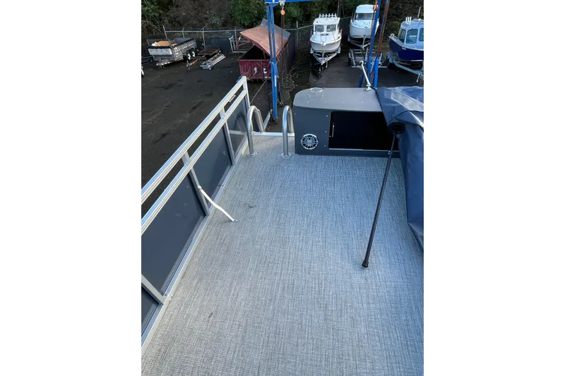 Slide: The Image of 2025 Tahoe Pontoon Cascade Cruise Funship deck with railing, docked near other boats. - 14