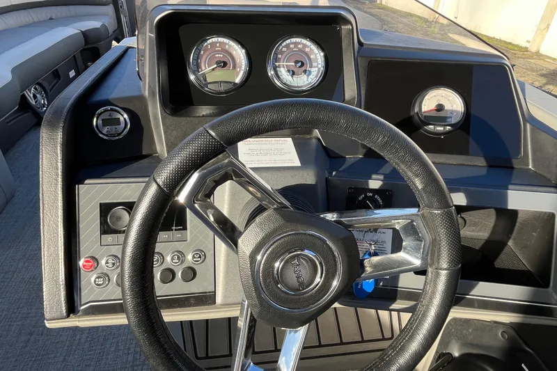 Slide: The Image of 2025 Tahoe Pontoon Cascade Cruise Funship dashboard with steering wheel and gauges. - 19