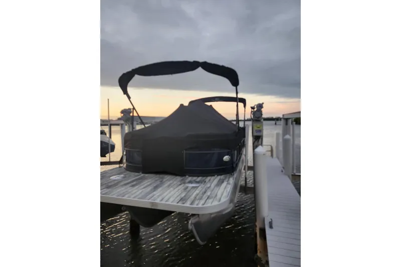 Slide: The Image of 2023 Veranda Fish VF25F2plus2 pontoon boat docked at sunset. - 2