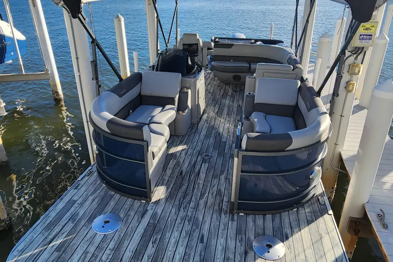 Slide: The Image of 2023 Veranda Fish VF25F2plus2 pontoon boat with spacious seating on a wooden deck. - 4