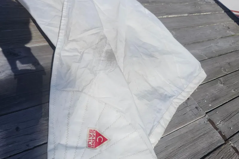 Slide: The Image of White sail with "Capri Sails" logo on wooden deck, Flying Tiger FT-10M, 2007. - 52