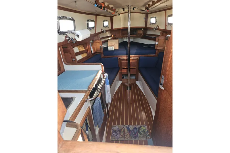Slide: The Image of Interior of 2003 Pacific Seacraft Dana 24 sailboat with wood finish and blue upholstery. - 13