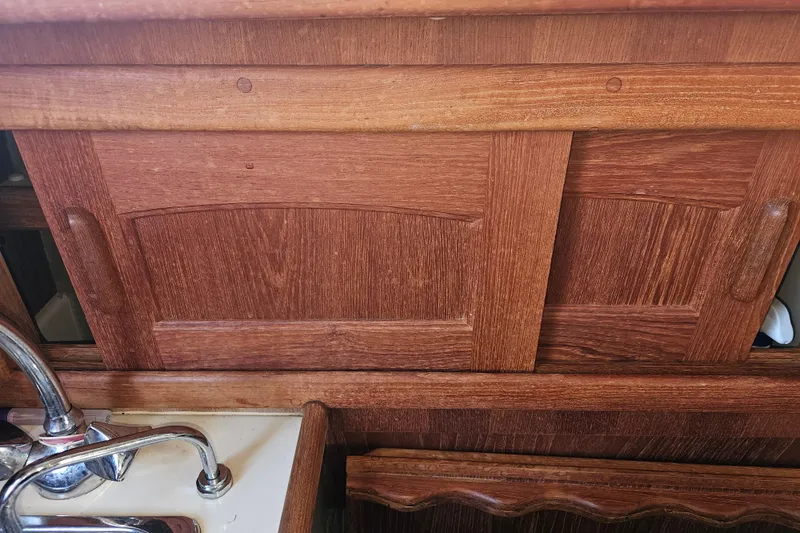 Slide: The Image of Wooden cabinetry and sink in 2003 Pacific Seacraft Dana 24 sailboat interior. - 18