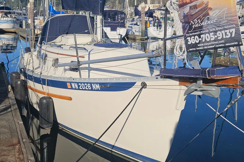 Slide: The Image of 2003 Pacific Seacraft Dana 24 sailboat docked in marina, featuring sleek design and visible registration. - 2