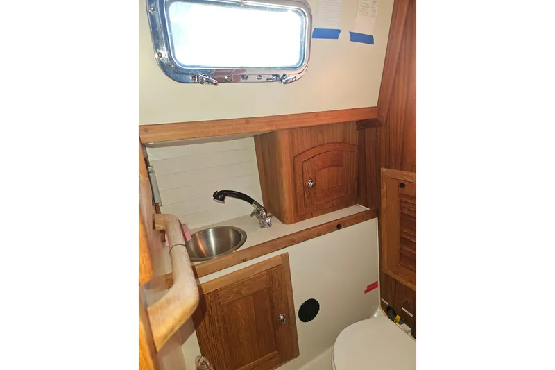 Slide: The Image of Interior of 2003 Pacific Seacraft Dana 24 sailboat, featuring a compact wooden bathroom. - 20