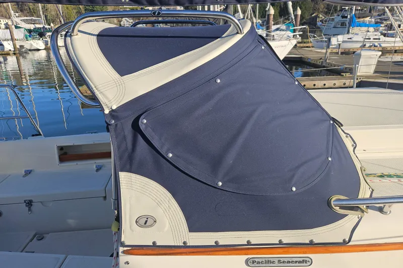 Slide: The Image of 2003 Pacific Seacraft Dana 24 sailboat with blue canvas cover at marina. - 6