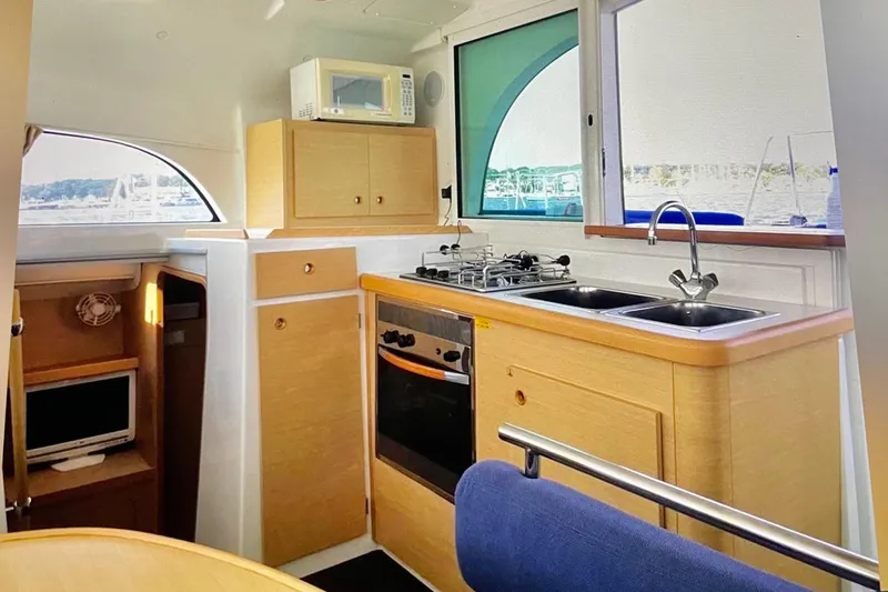 Slide: The Image of Interior of 2008 Lagoon 380 S2 yacht kitchen with stove, sink, and microwave. - 12