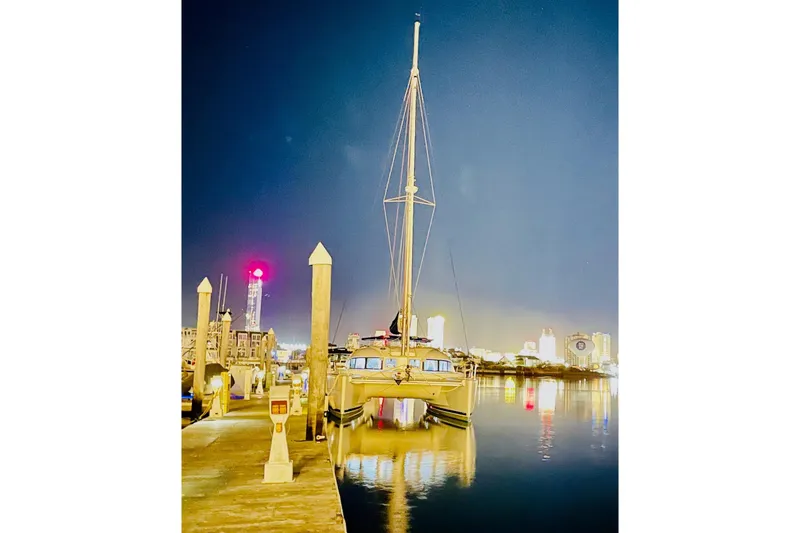 Slide: The Image of Lagoon 380 S2 catamaran docked at night, city skyline in background, 2008 model. - 16