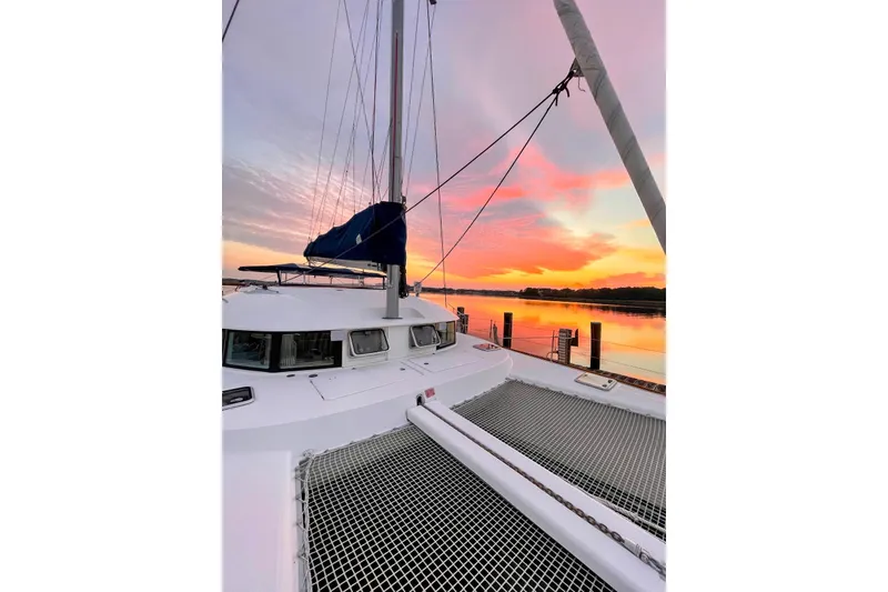 Slide: The Image of Lagoon 380 S2 catamaran at sunset, 2008 model, docked by serene waters. - 17