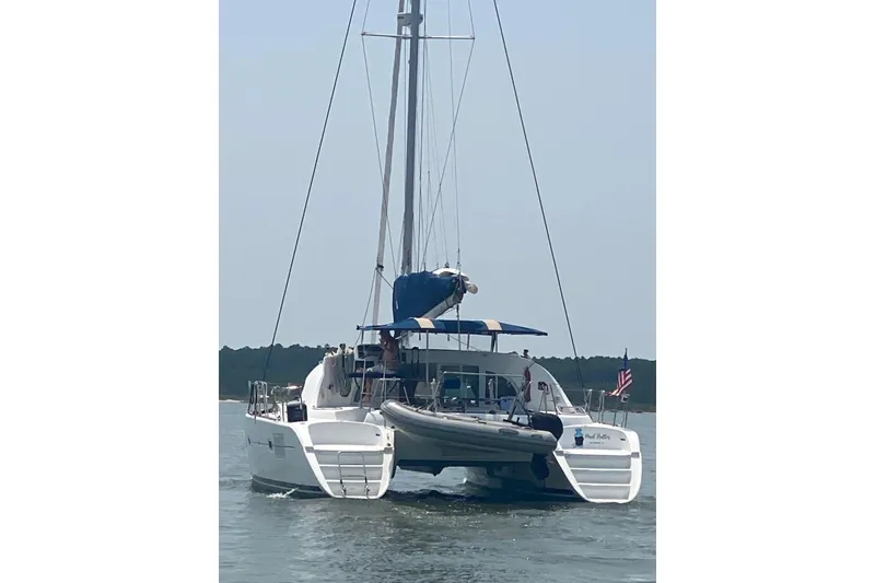 Slide: The Image of 2008 Lagoon 380 S2 catamaran sailing on calm waters with American flag. - 18