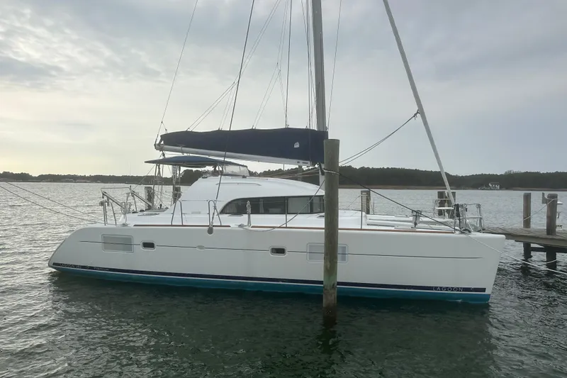 Slide: The Image of 2008 Lagoon 380 S2 catamaran docked on calm water under cloudy sky. - 20