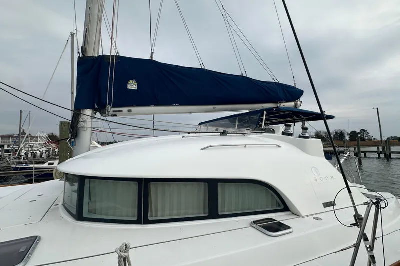 Slide: The Image of 2008 Lagoon 380 S2 catamaran docked at marina, featuring sleek design and blue sail cover. - 22