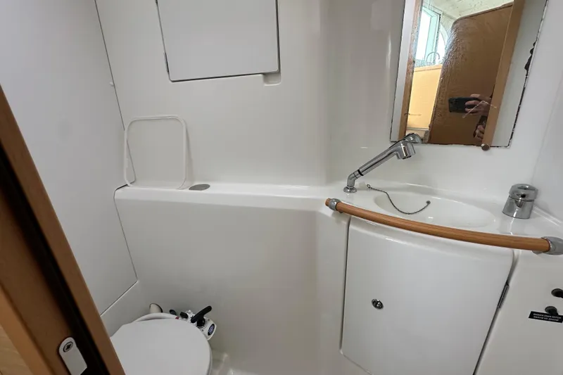 Slide: The Image of Compact bathroom in 2008 Lagoon 380 S2 yacht with sink, mirror, and toilet. - 26