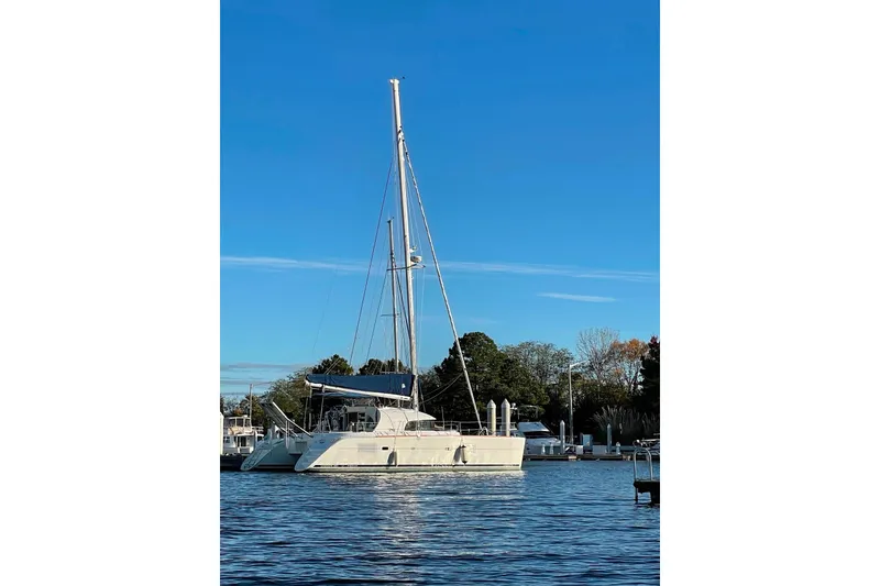 Slide: The Image of 2008 Lagoon 380 S2 catamaran docked on calm water under clear blue sky. - 4