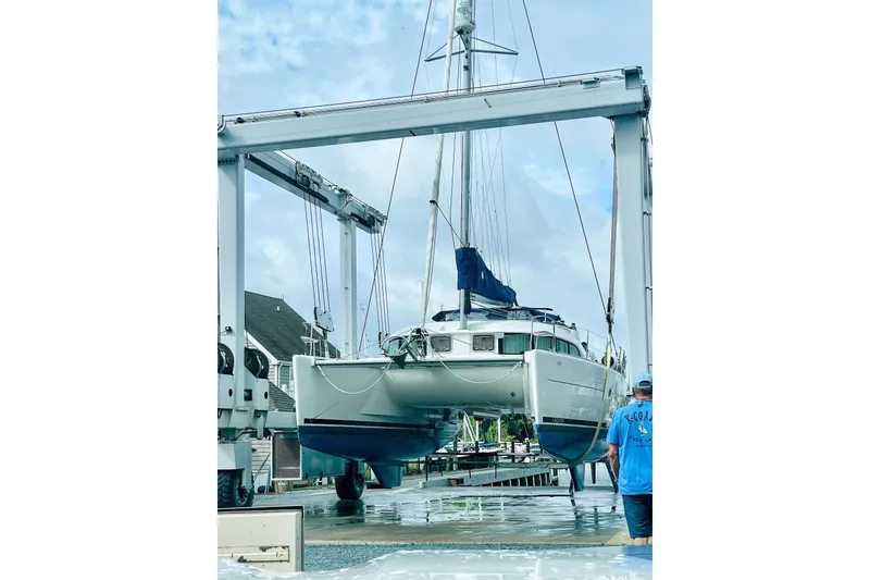 Slide: The Image of 2008 Lagoon 380 S2 catamaran being lifted at a marina. - 6