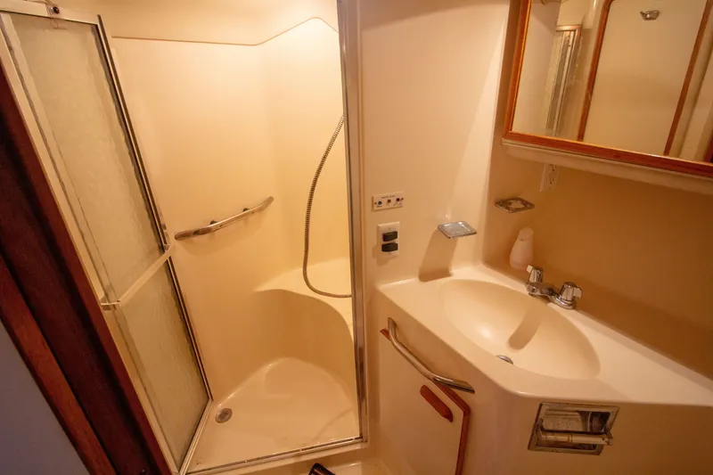 Slide: The Image of 1993 Sea Ray 440 Express Bridge bathroom with shower and sink. - 48