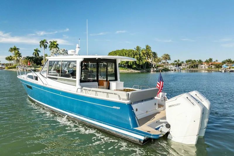 Slide: The Image of 2026 MJM 47R boat with dual Mercury engines on a sunny waterway. - 42