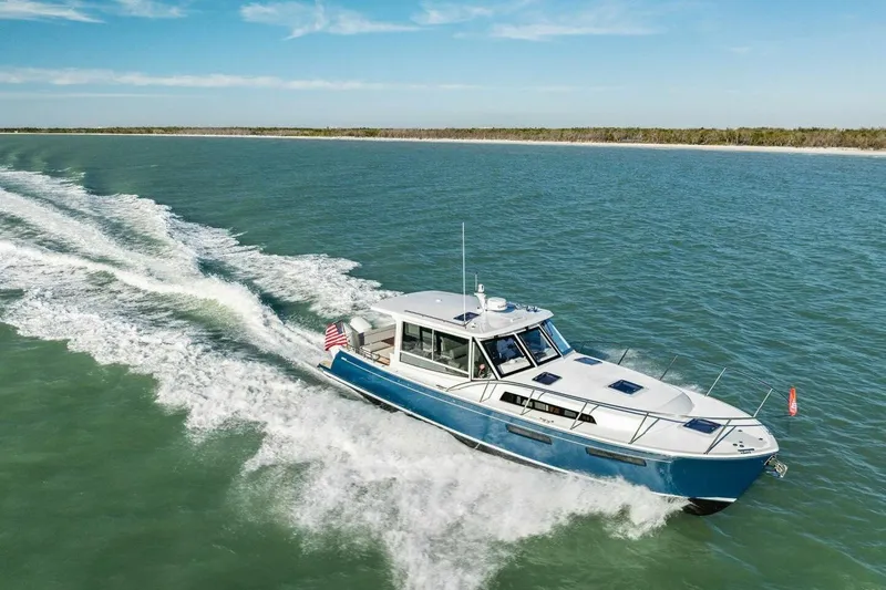 Slide: The Image of 2026 MJM 47R yacht cruising on open water under clear blue skies. - 45