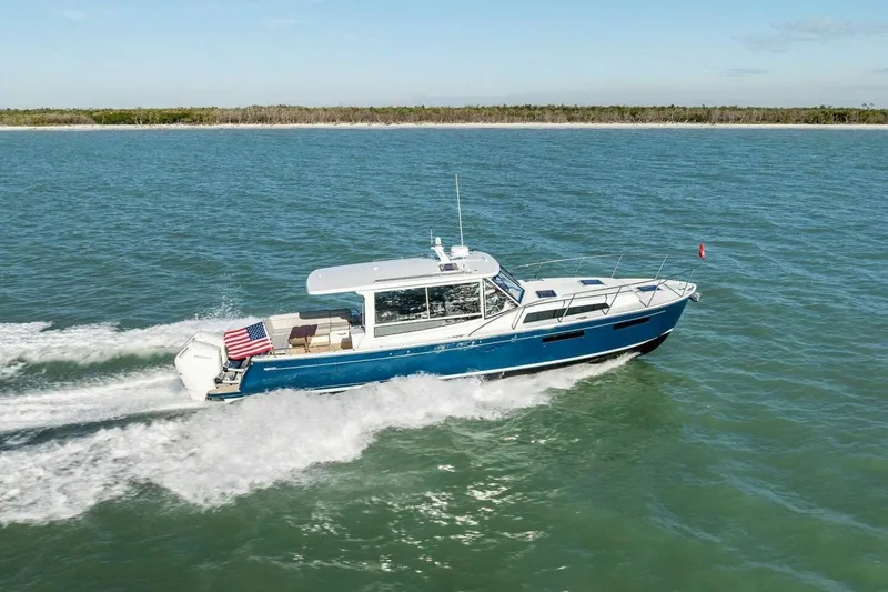 Slide: The Image of 2026 MJM 47R boat cruising on open water under clear skies. - 46