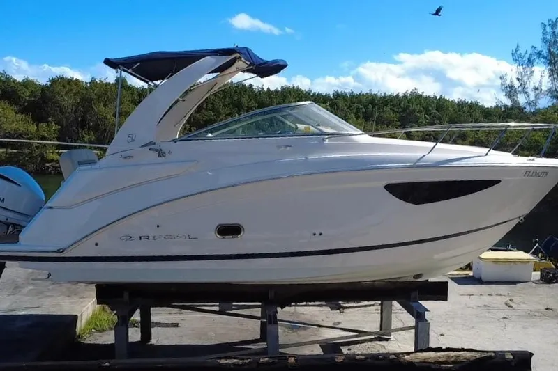 Slide: The Image of 2021 Regal 26 XO boat on display, featuring sleek design and canopy, outdoors. - 13