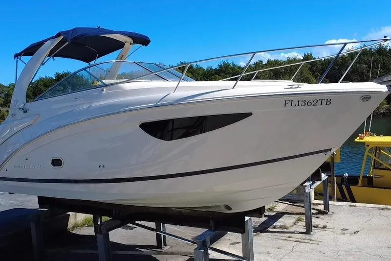 Slide: The Image of 2021 Regal 26 XO boat on a stand, featuring sleek design and blue canopy. - 14