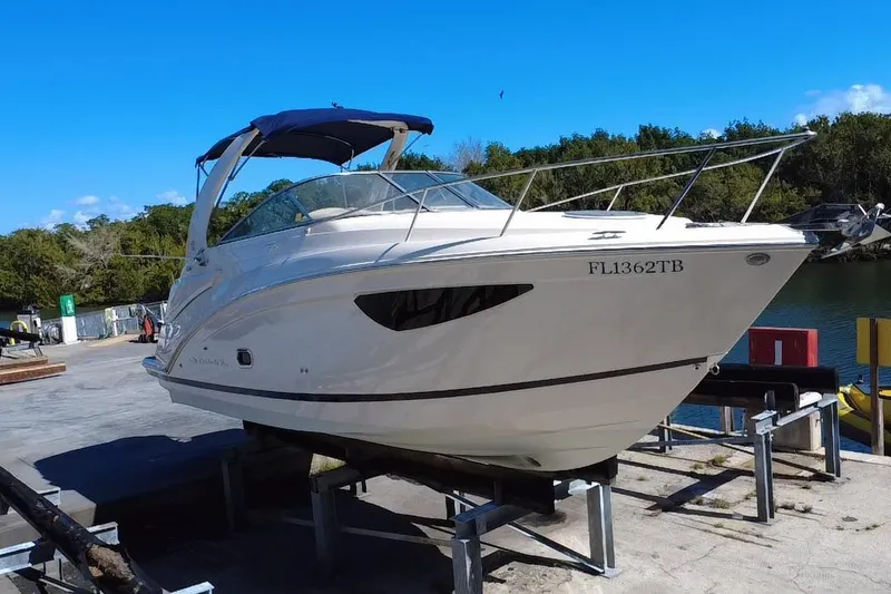 Slide: The Image of 2021 Regal 26 XO boat on a lift, featuring sleek design and blue canopy. - 15