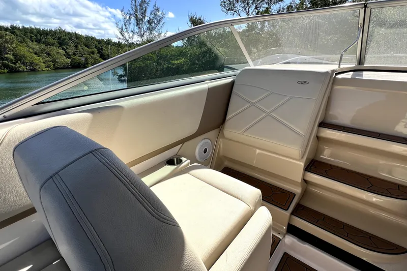 Slide: The Image of Interior of 2021 Regal 26 XO boat with beige seating and wooden steps. - 26