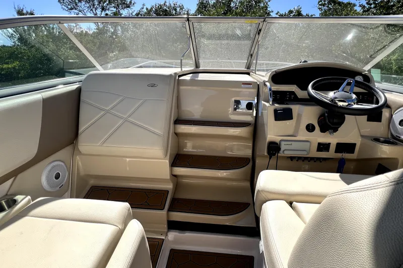 Slide: The Image of Interior of a 2021 Regal 26 XO boat, featuring beige seating and modern controls. - 27