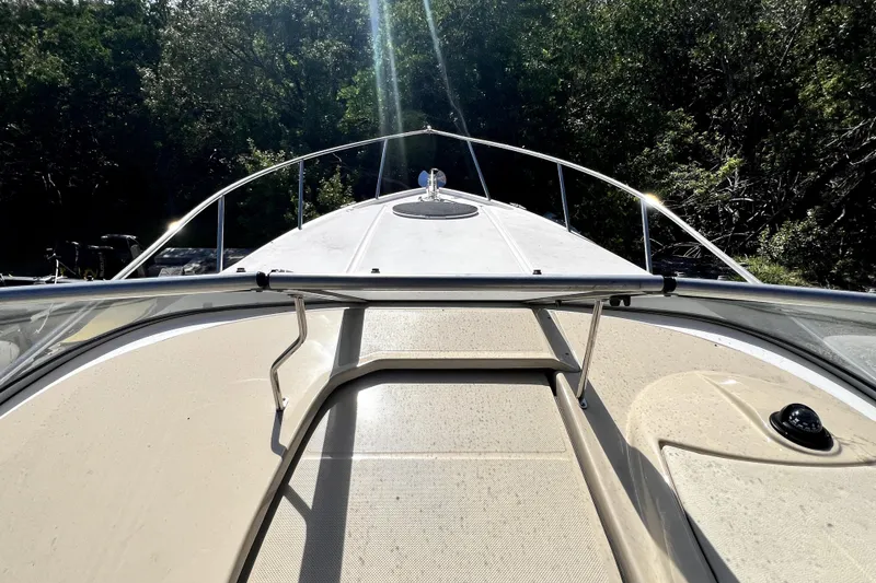 Slide: The Image of 2021 Regal 26 XO boat deck with railing, surrounded by lush greenery. - 30