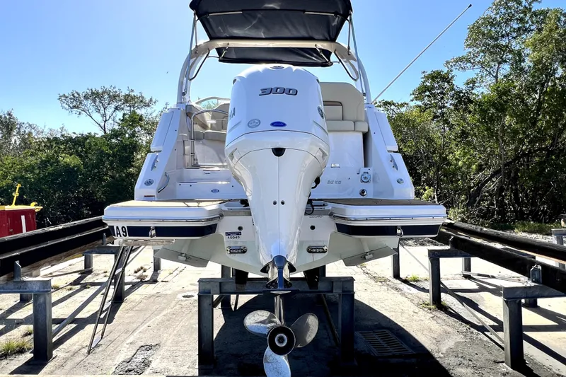 Slide: The Image of 2021 Regal 26 XO boat with Yamaha engine on a trailer, surrounded by trees. - 9