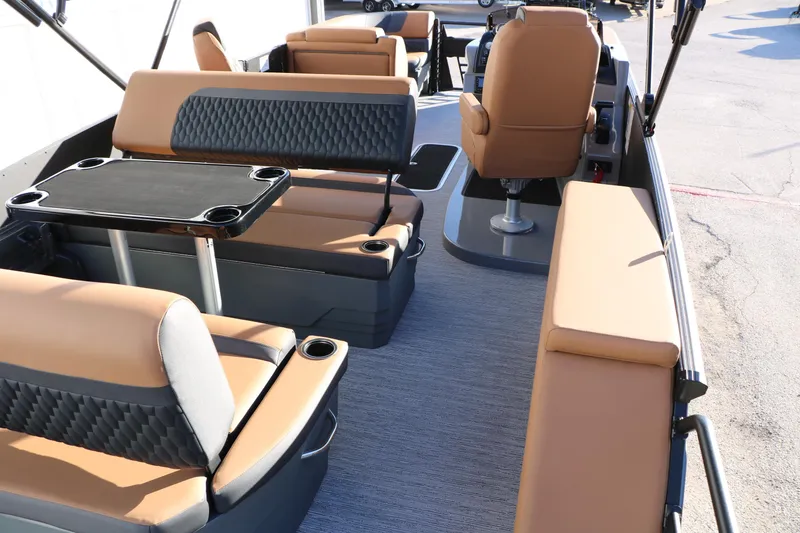 Slide: The Image of 2026 Sylvan L3 LZ DH Platinum Edition Tri-Toon interior with tan seating and table. - 27