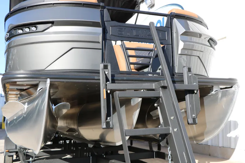 Slide: The Image of 2026 Sylvan L3 LZ DH Platinum Edition Tri-Toon boat, rear view with ladder and pontoons. - 4
