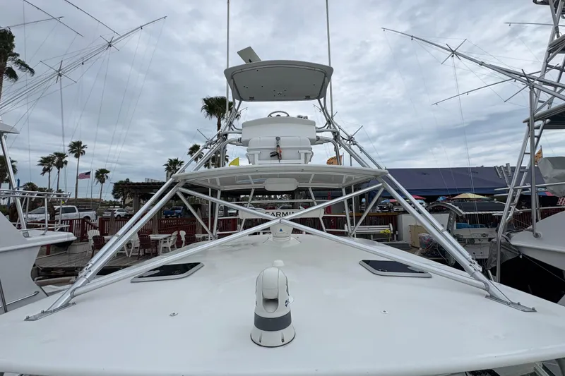 Slide: The Image of 2004 Cabo 40 Hardtop Express boat docked, featuring a sleek design and tower structure. - 17