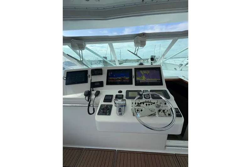 Slide: The Image of Helm of 2004 Cabo 40 Hardtop Express with navigation screens and controls. - 19