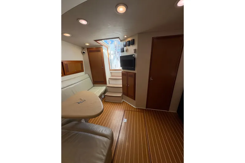 Slide: The Image of Interior of 2004 Cabo 40 Hardtop Express yacht with seating, table, and TV. - 24
