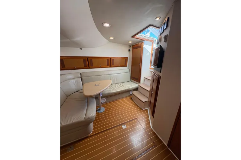 Slide: The Image of Interior of 2004 Cabo 40 Hardtop Express yacht with leather seating and wooden flooring. - 25