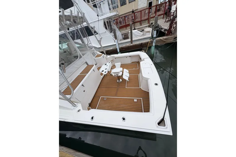 Slide: The Image of 2004 Cabo 40 Hardtop Express boat with teak deck, docked at marina. - 4