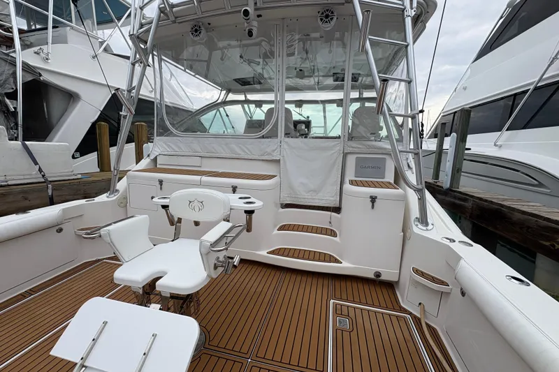 Slide: The Image of 2004 Cabo 40 Hardtop Express boat with teak deck and fishing chair in marina. - 5